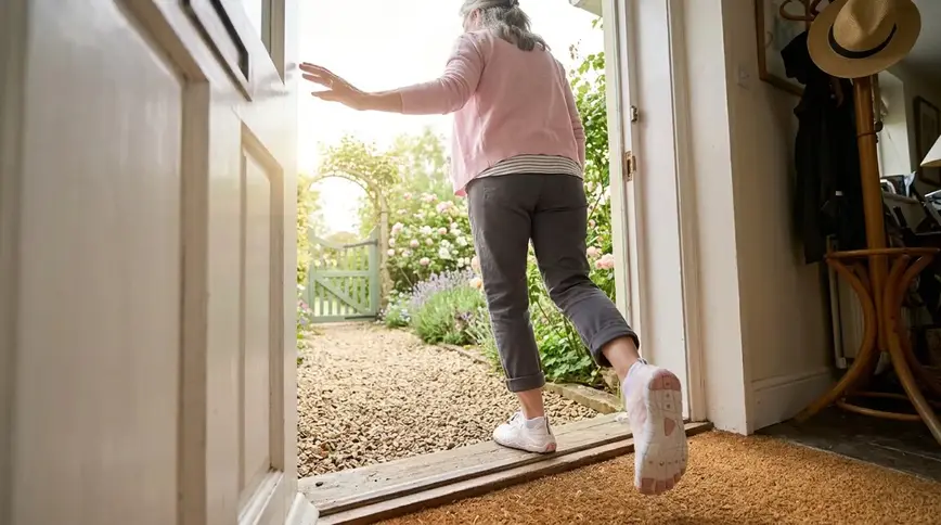 Woman putting on Motion Ground shoes at front door
